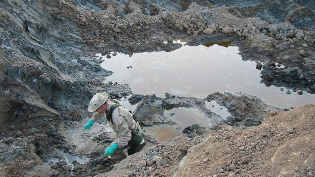 The researcher explores substances in the excavation grave