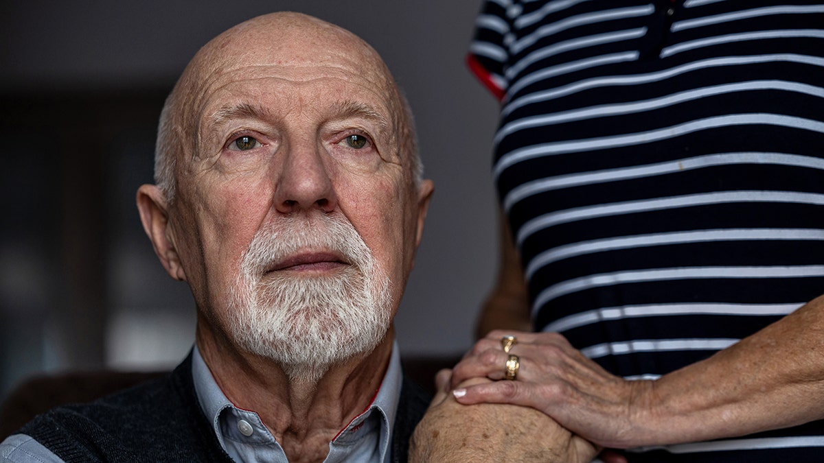 Portrait of an old man with his caregiver in the background