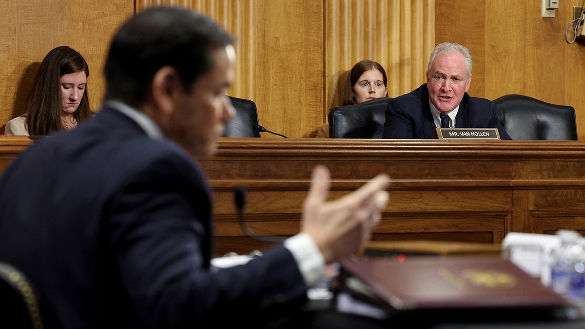 Senator Chris Van Hollen speaks while Secretary of State Marco Rubio makes gestures