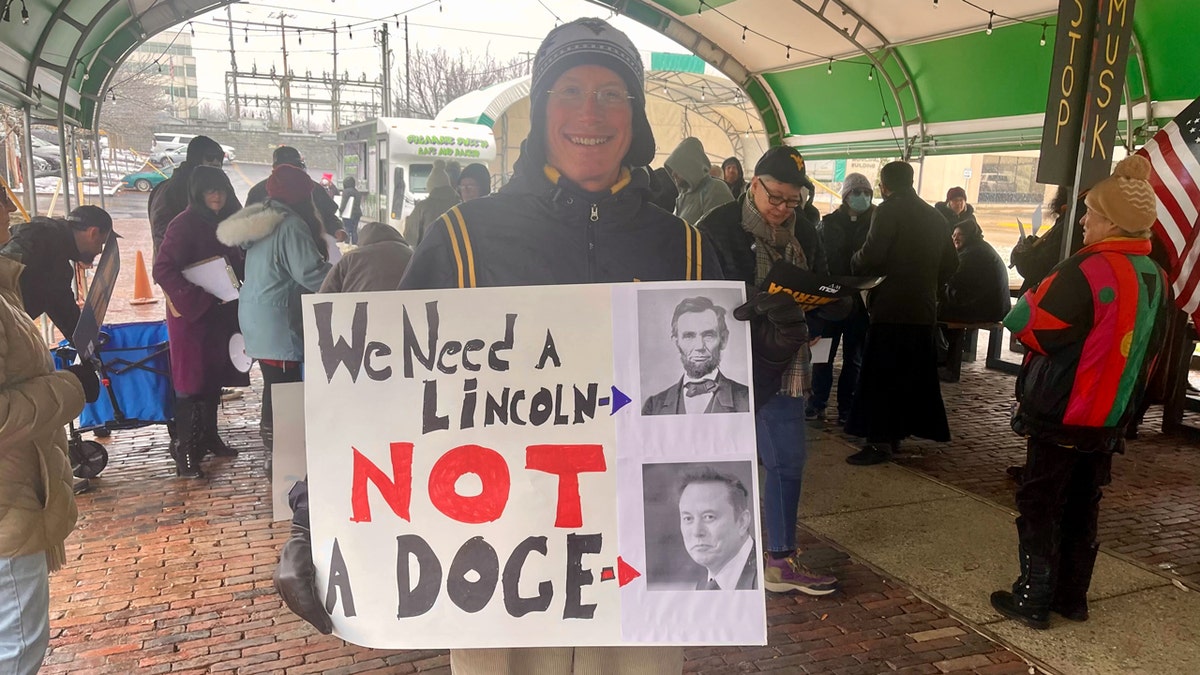 On Tuesday, a DOGE protester has a sign in Parkersburg, Western Virginia.