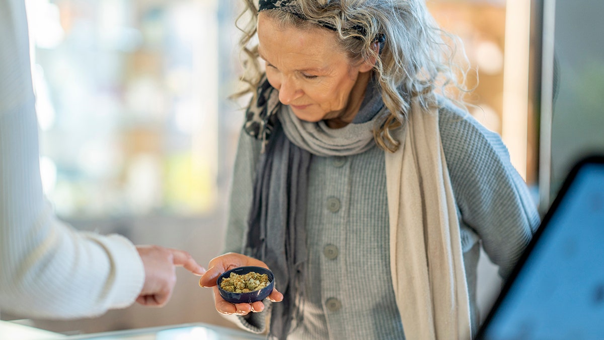 The woman is on the counter of a cannabis retailer